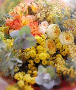 オレンジのバラ・黄色のマトリカリア・ミモザ・アイビーを使った花束の写真