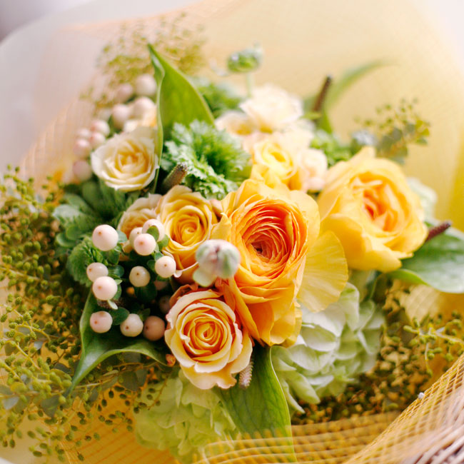 オレンジのバラ・オレンジのラナンキュラス・グリーンのラナンキュラス・
ヒペリカム・グリーンのアンスリューム・ユーカリの実を使った花束の写真